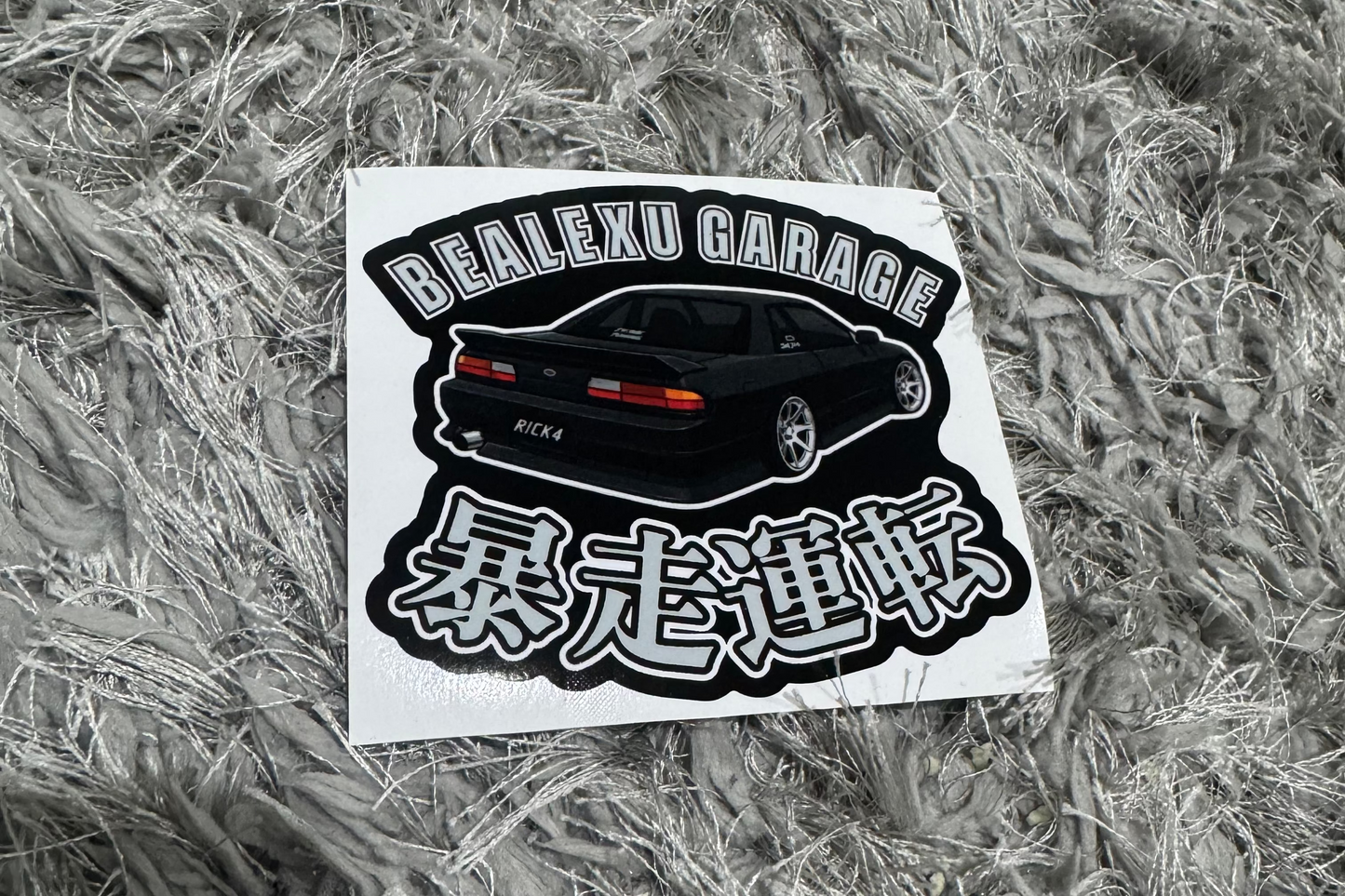 Sticker with text and graphics on a textured gray surface